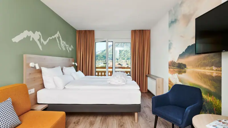 Zimmer & Suiten Ein Zimmer mit einem Bett und einem Stuhl.