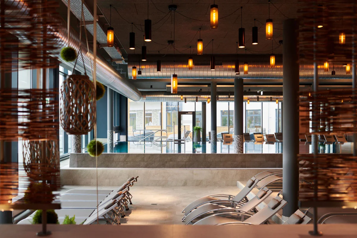 Ruhebereich in der Badewelt im aja SPA Ruhpolding Ein Raum mit Stühlen und einem Pool.