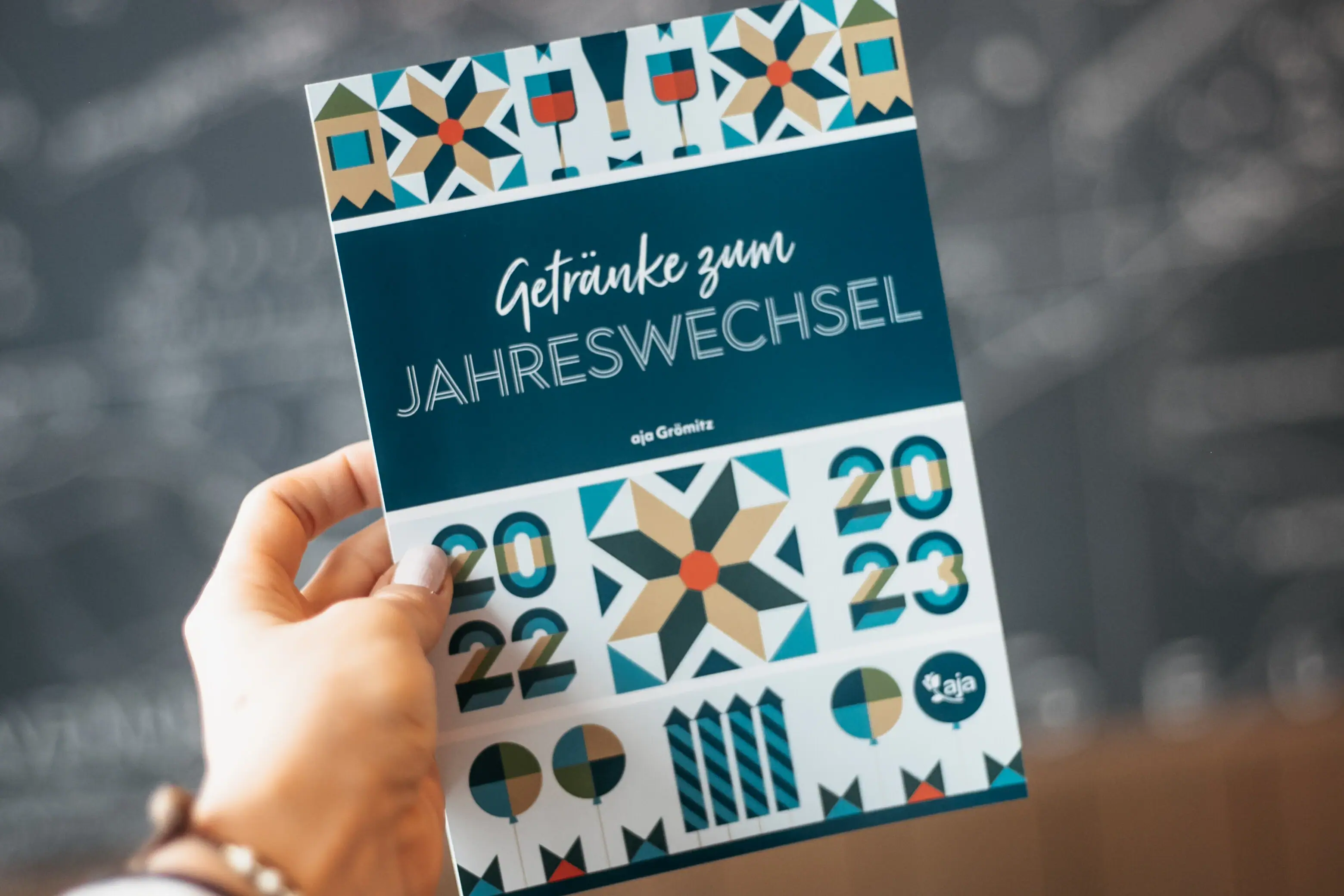 Eine Hand hält ein Programmheft der Silvesterparty.