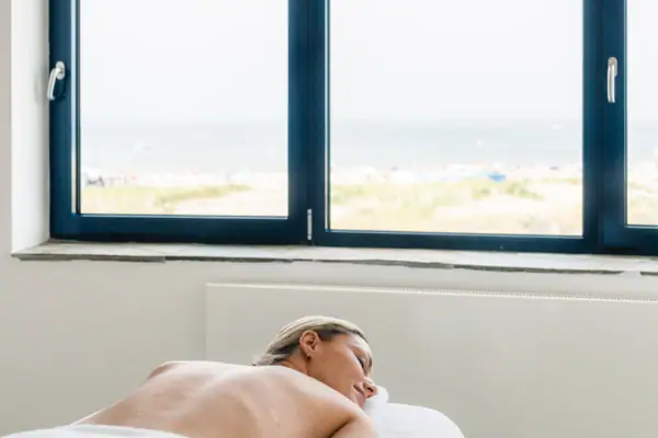 Eine Frau liegt auf einem Massagetisch.