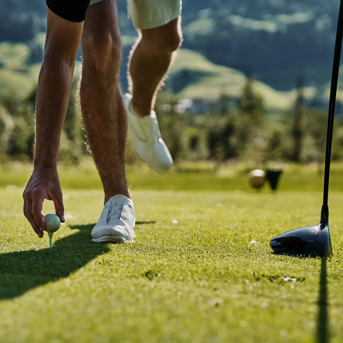 Eine Person hält einen Golfball auf einem Golfplatz in Ruhpolding.