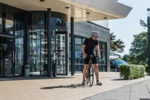 Ein Mann auf einem Fahrrad vor einem Gebäude.
