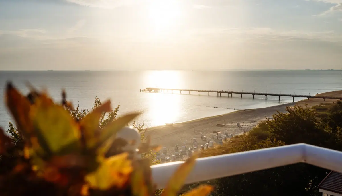 Ein Strand mit einem Pier und einem Gewässer.