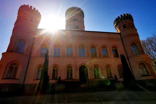 Großes Gebäude mit Uhrturm vor klarem Himmel.