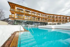 Ein Pool vor einem Gebäude mit klarem Himmel im Hintergrund.