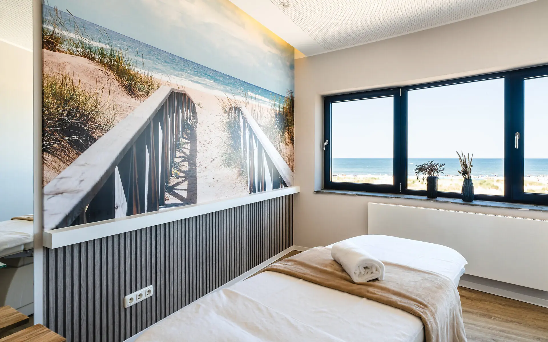 Ein Zimmer mit Liegen und einem Gemälde an der Wand.