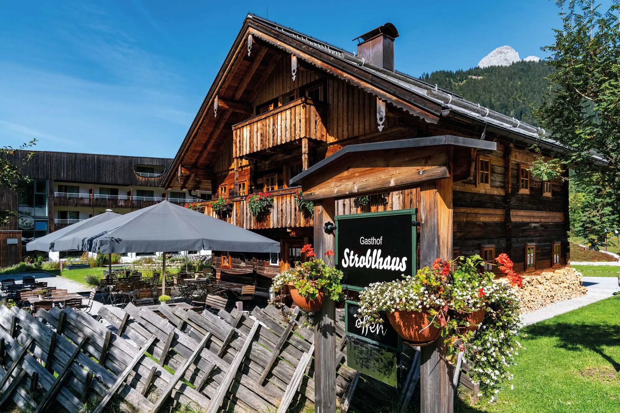 Das Restaurant Stroblhaus in einem Holzhaus mit Schild davor.