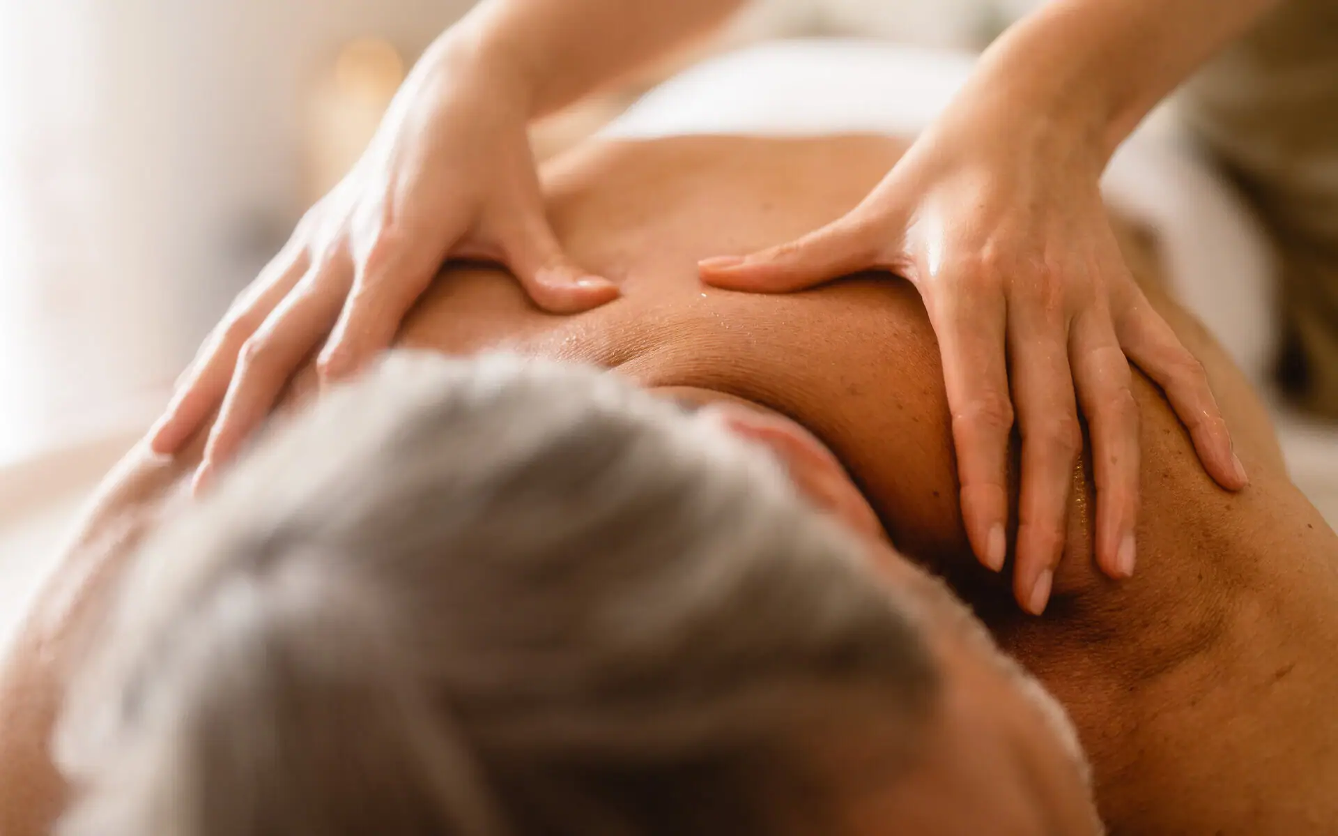 Person erhält eine Rückenmassage.
