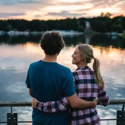 Ein Mann und eine Frau umarmen sich an einem See.