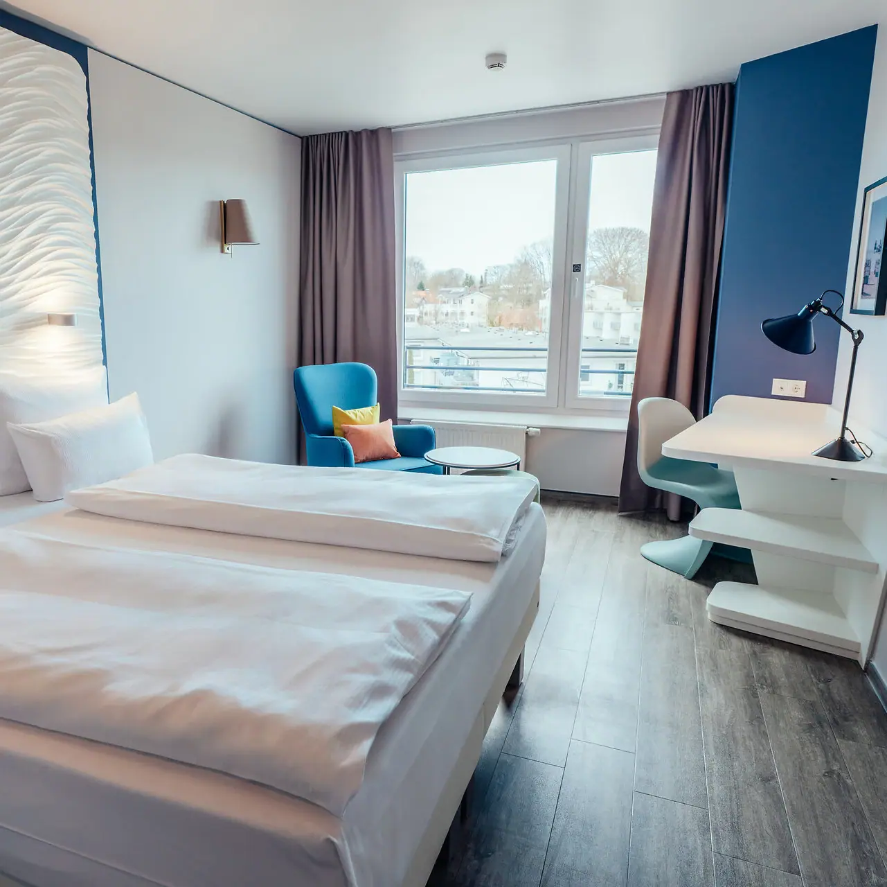 Ein Zimmer mit zwei Betten und einem Tisch.