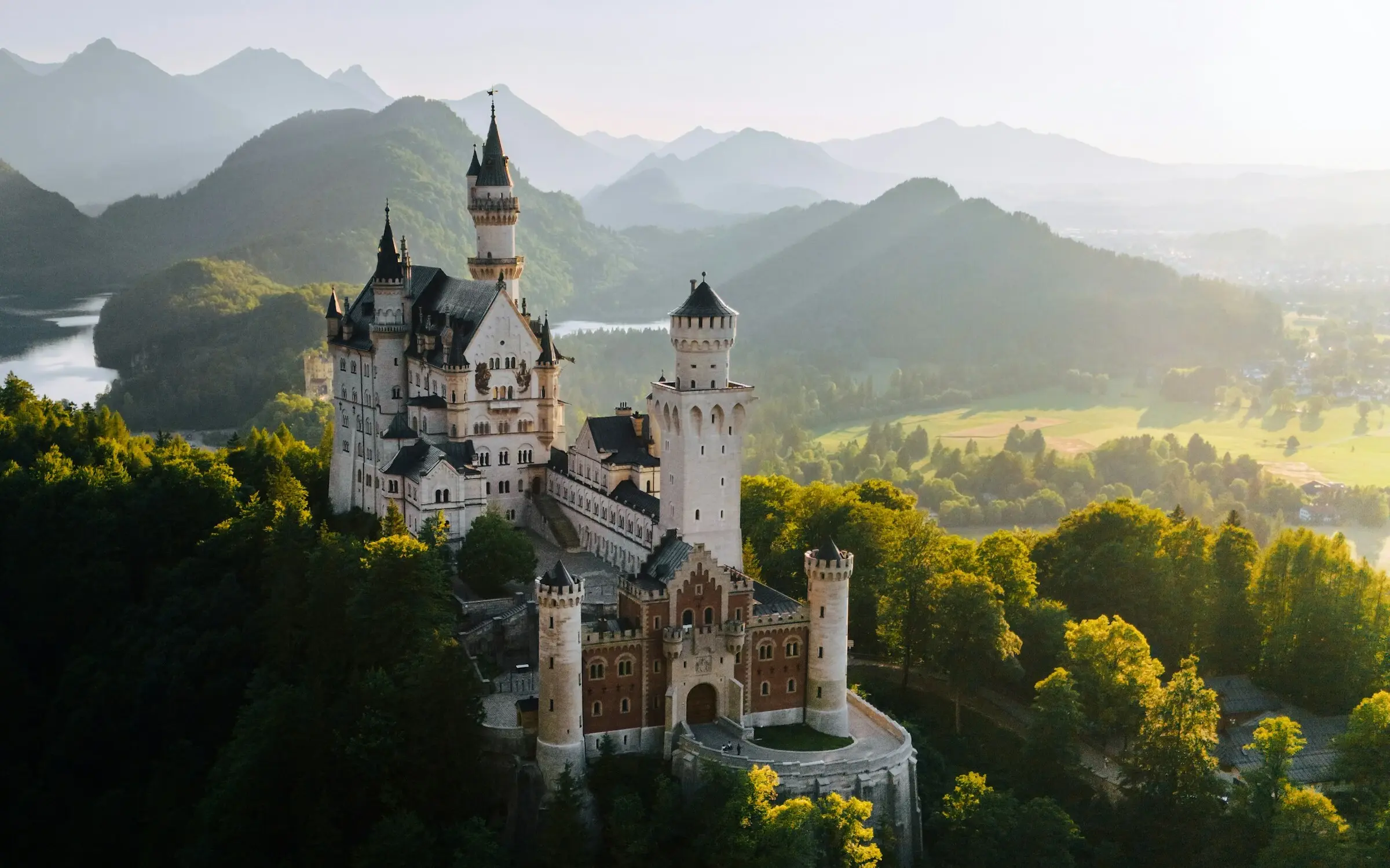 Das Schloss Neuschwanstein auf einem Hügel, umgeben von Bäumen.