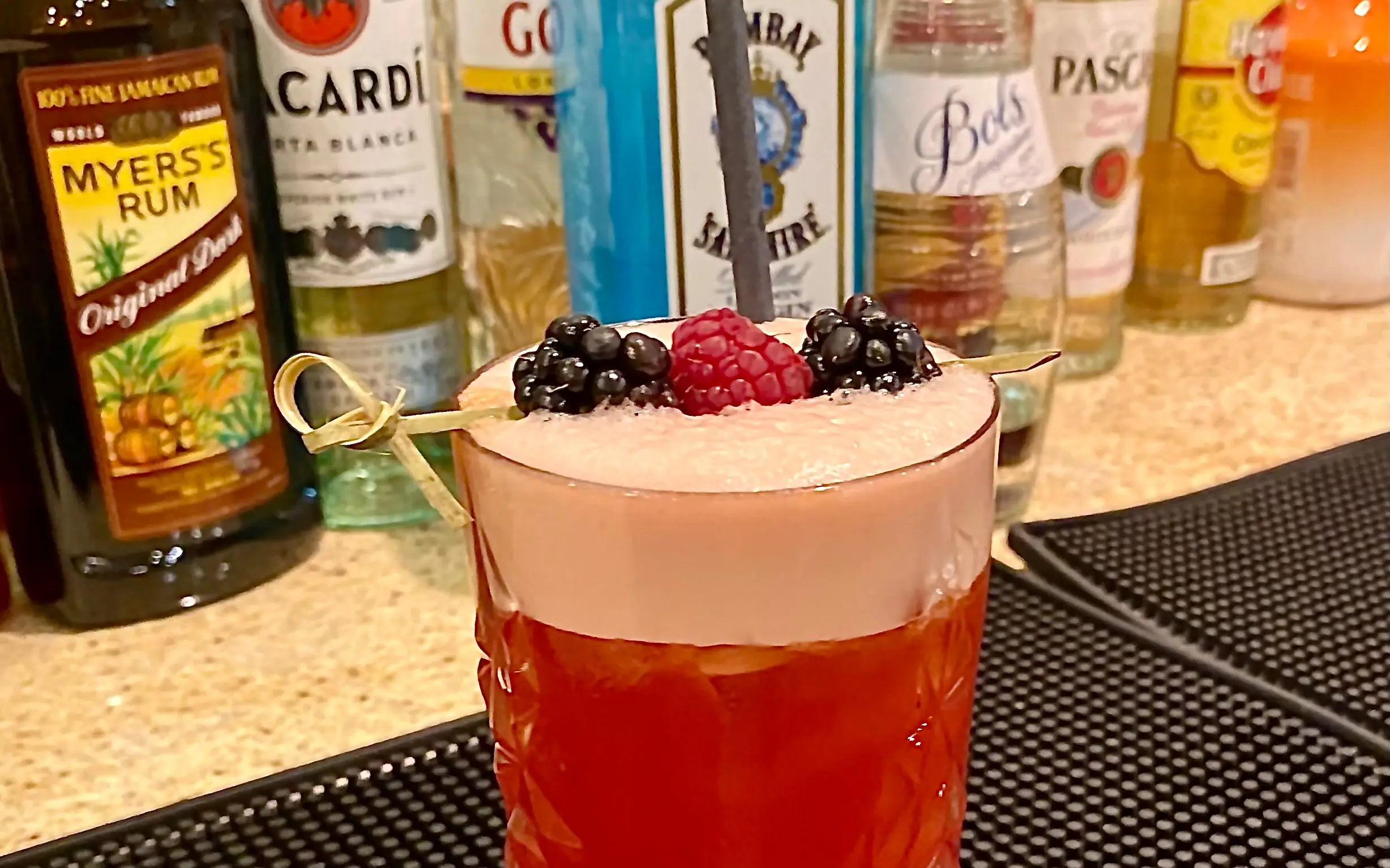 Nahaufnahme eines Glases mit Flüssigkeit und Beeren.