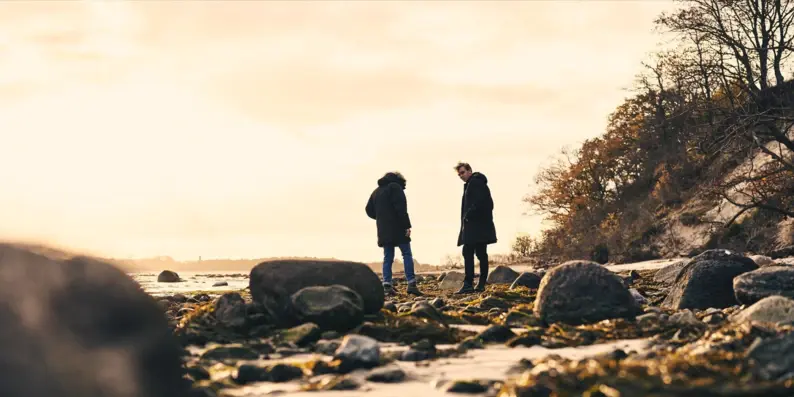 Ein Paar steht auf einem felsigen Strand.