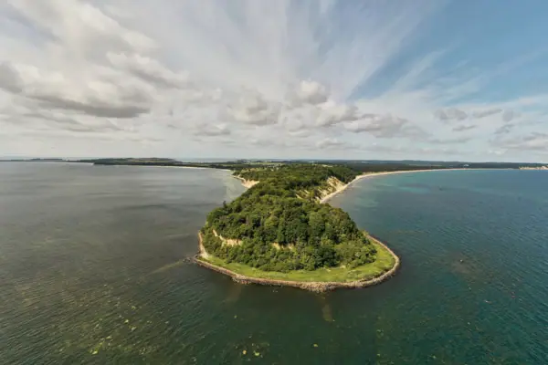 Eine Insel im Wasser unter einem bewölkten Himmel.