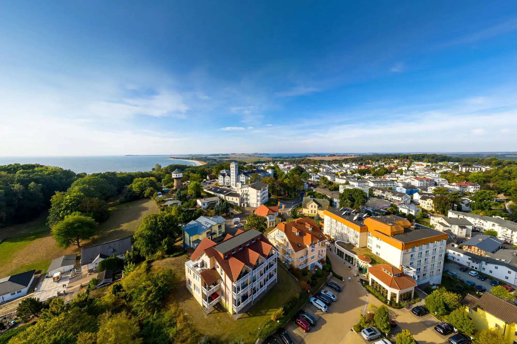 Luftaufnahme von Göhren auf Rügen mit Blick auf das Nordperd & Villen Hotel, die Ostseeküste und die umliegenden Villen bei strahlendem Sommerwetter.
