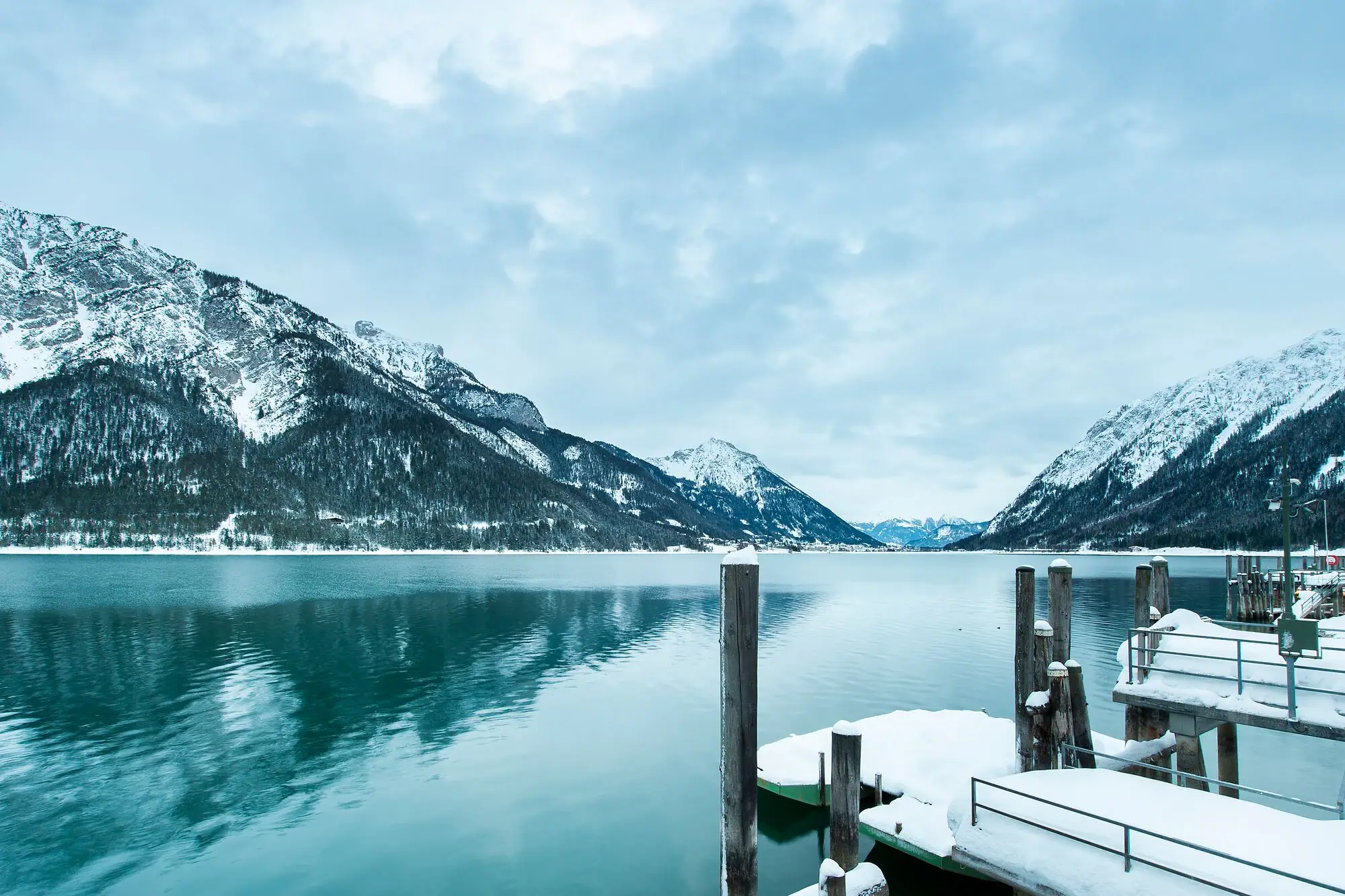 Ein schneebedeckter Steg an einem See.