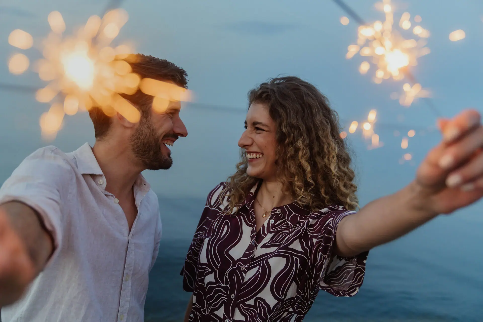 Ein Mann und eine Frau feiern Silvester in Bansin mit Wunderkerzen.