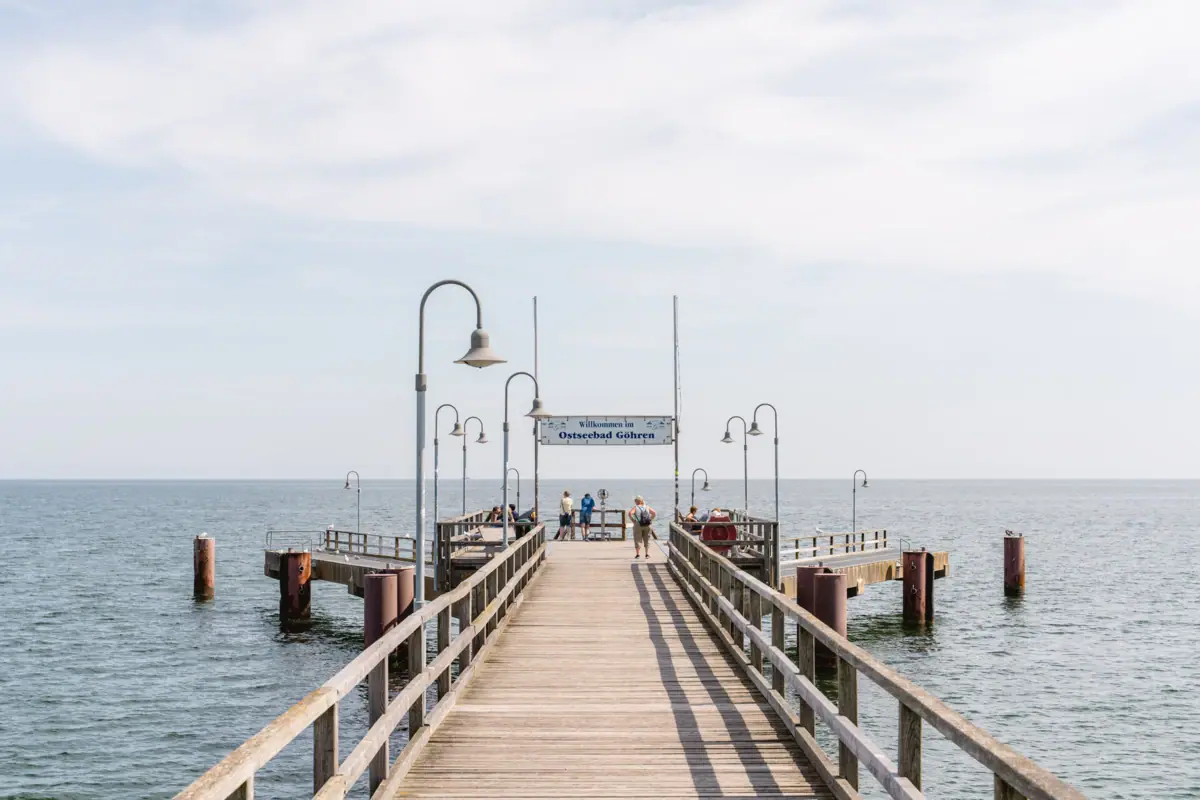Holzsteg mit Menschen, die darauf spazieren gehen.